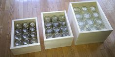 three boxes filled with empty glasses sitting on top of a wooden floor