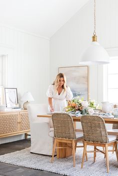 a woman standing in front of a dining room table