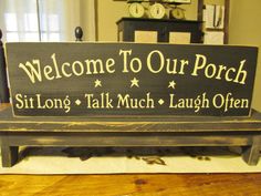 a wooden sign that says, welcome to our porch sit long talk much laugh often