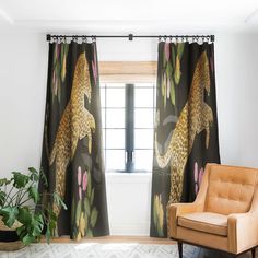 a living room with a leopard print curtain and chair in front of the window, next to a potted plant