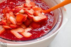 strawberries and other fruit are mixed in a bowl