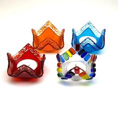 three different colored glass masks sitting next to each other