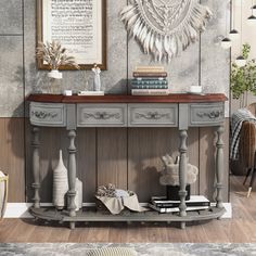 a console table with books and vases on it