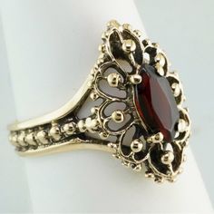 This 10k Yellow Gold Ring Holds An 8x4mm Marquise Cut Natural Garnet. Classic Garnet Rings With Intricate Design, Classic Garnet Jewelry Stamped 14k, Classic 14k Stamped Garnet Jewelry, Ornate 14k Gold Ruby Ring For Anniversary, Classic 14k Garnet Jewelry, Ornate 14k Gold Promise Ring, Classic Filigree Ring With Gemstone In 14k Gold, Classic 14k Gold Filigree Ring With Gemstone, Classic Filigree Ring In 14k Gold With Gemstone