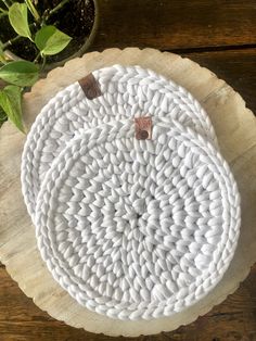 a white plate sitting on top of a wooden table next to a potted plant