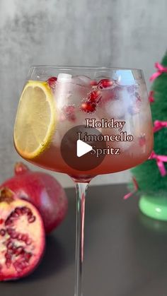 a pomegranate and lemon drink in a wine glass with the words holiday limonocello spritz