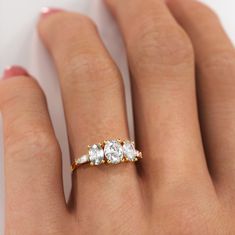 a woman's hand with three diamond rings on it