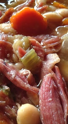 a bowl filled with meat, beans and carrots