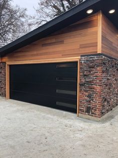 two garages are built into the side of a house with brick and wood siding