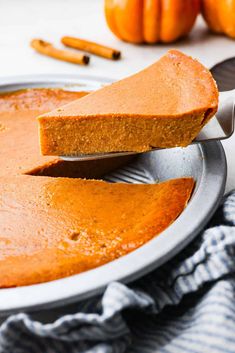 a pumpkin pie being cut with a knife