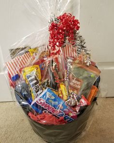 a basket filled with candy and candies on top of a carpeted floor next to a door