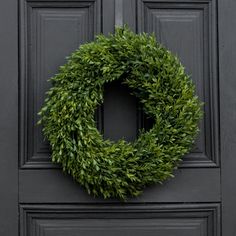 a black door with a green wreath on it