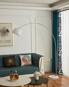 a living room with a couch, table and lamp on the wall next to it