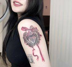 a woman with a heart tattoo on her arm