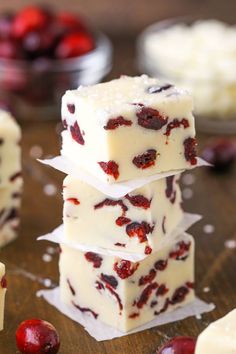 three pieces of white chocolate with cranberry toppings stacked on top of each other