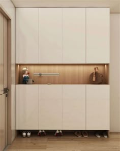 an empty room with white cupboards and shoes on the floor in front of it