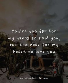 two people sitting in the back of a truck with text that reads, you're too far for my hands to hold you, but too near for my heart to love