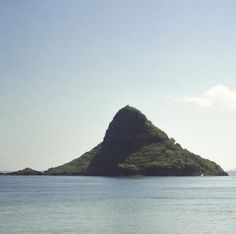 an island in the middle of water with a boat out on it's side