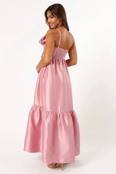 a woman is wearing a pink dress with ruffles on the bottom and back