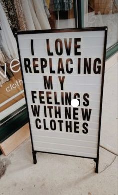 a sign that says i love replacing my feelings with new clothes in front of a store