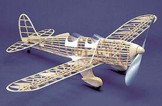 a wooden model of an airplane on a blue background