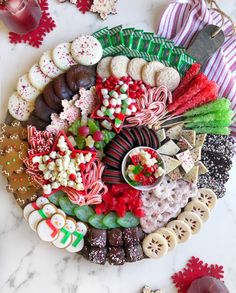 a platter filled with lots of different types of cookies and candies on top of a table