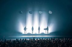 three people standing on a stage in front of a crowd