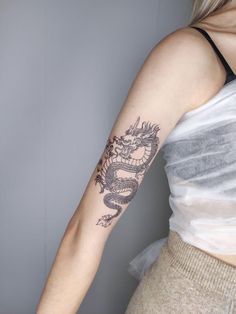 a woman with a dragon tattoo on her arm