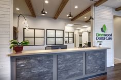 the front desk of a dental office with wood floors and exposed beams on the ceiling