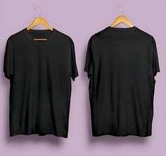 two black t - shirts hanging on a wooden hanger against a purple wall,