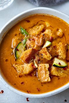 a bowl of soup with tofu, zucchini and spinach in it