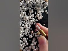 a person holding a cell phone with pearls on it