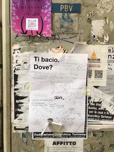 a bunch of papers that are on the side of a door with graffiti written on it