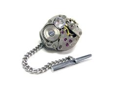 Classic Oval Watch Gear Steampunk Tie Tack by Kiola Designs A perfect gift for classy and mysterious steampunk lovers. Makes a great gift for your wedding's groomsmen.  The tie tack is made out of upcycled real watch gears. They are NOT operational/move. Since the watch gears are upcycled, the watch gears are not new.  The tie tack is roughly 5/8 inch wide (from left to right) by 1/2 inch high (top to bottom) Oval Watch, Watch Gears, Steampunk Watch, Wedding Groomsmen, Steampunk Jewelry, Tie Clips, Tie Tack, Wedding Gift Favors, Tie Accessories