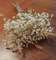 a bunch of white flowers sitting on top of a wooden table next to a bird