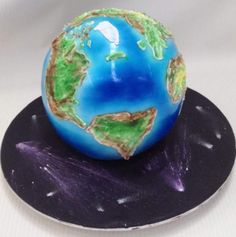 a blue and green earth sitting on top of a black plate