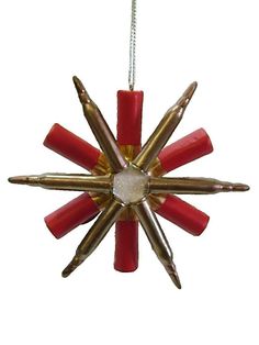 a red and gold star ornament hanging from a chain