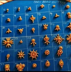 beads are arranged in rows on a blue table with numbers and symbols for each bead