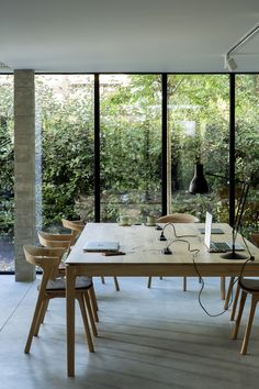 the table is surrounded by wooden chairs and plants