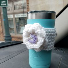 a crocheted flower on the side of a coffee cup