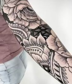 a woman's arm with flowers on it and an ornate design in the middle