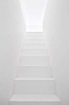 a white staircase leading up to an open skylight