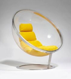 a glass chair with yellow cushions on it