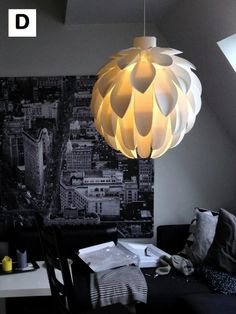 a lamp hanging from the ceiling in a living room next to a dining room table