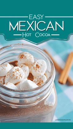 a jar filled with hot chocolate and marshmallows on top of a table