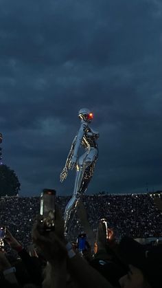 a person holding up a cell phone in front of a crowd