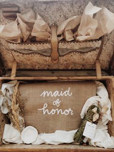 an old suitcase with the word maid of honor written on it and some dried flowers