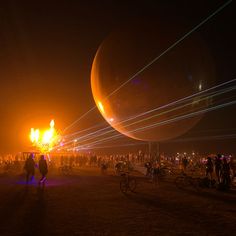 people standing around at night with lights and balloons in the air