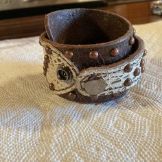 A Previously Owned New Without Tags Brown Studded Leather Cuff Bracelet. It Is 16” Long And Is 3/4”-2-3/4” Wide. It Has 2 Snaps For Easy Adjustment. A Great Addition To Your Leather Bracelet Collection. Thank You For Looking!!! Thick Leather Bracelet, Adjustable White Leather Bracelets, Adjustable Leather Strap Cuff Jewelry, Adjustable Brown Cuff Jewelry, Adjustable Leather Bracelet With Snap Closure, Brown Cuff Leather Bracelet, Adjustable Concho Cuff Jewelry, Vintage Adjustable Cuff Bracelet, Vintage Adjustable Cuff Bracelet As Fashion Accessory