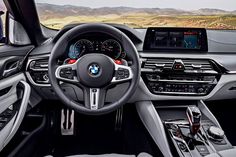 the interior of a bmw car with dashboard, steering wheel and infotains on display